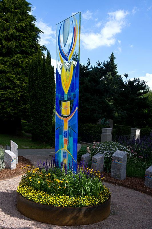 Blumenbeet Kunstwerk in Gelb und Blau vor Himmel auf dem Friedhof Rellingen