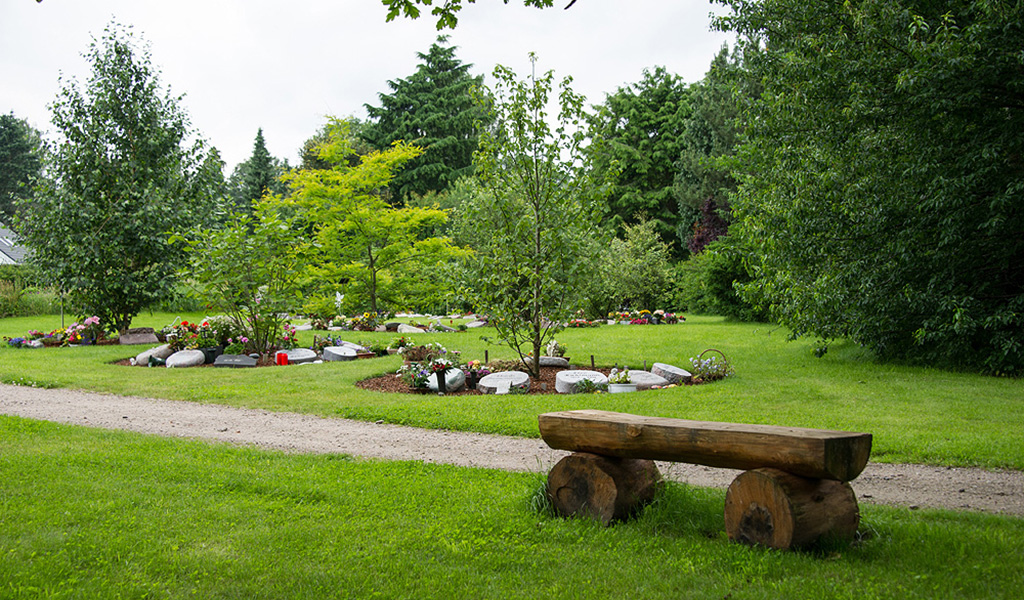 Baumpark mit Sitzbank auf dem Friedhof Rellingen